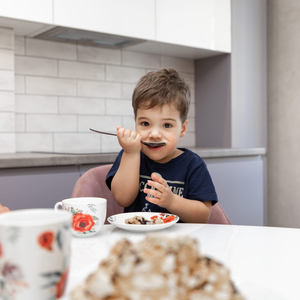Ребенок ест дисерт на новой кухне